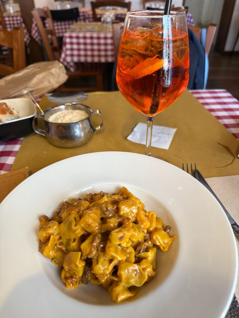 An Aperol spritz on a checkered tablecloth at a restaurant in Florence
