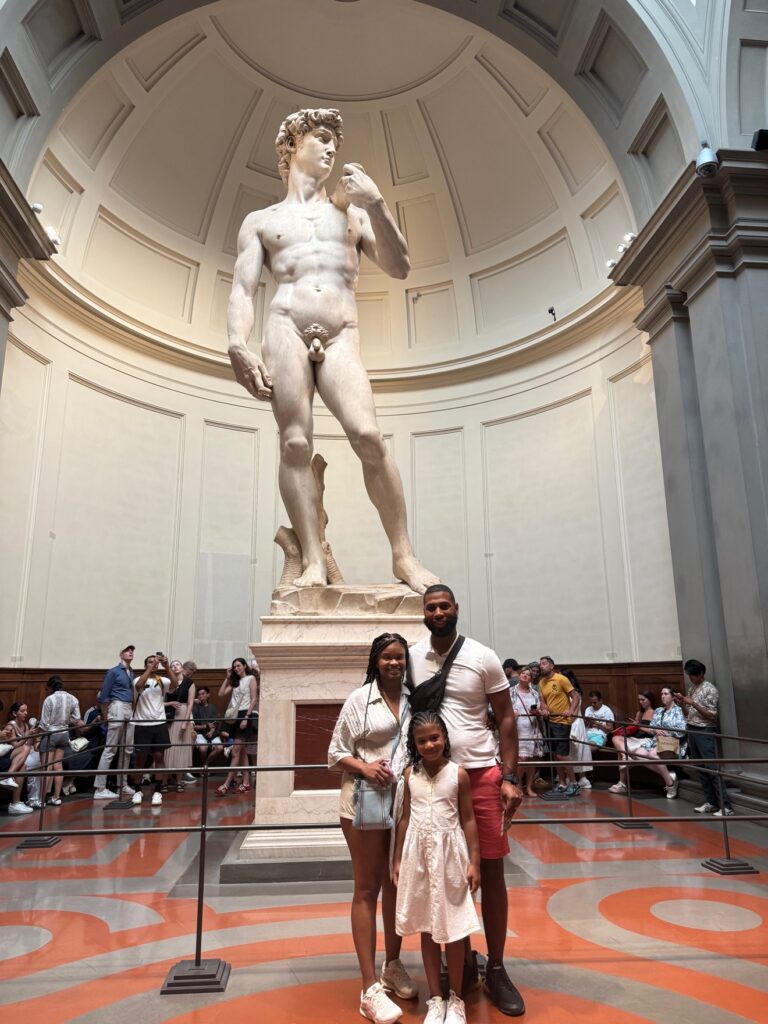 Dominique with his wife and daughter in front of Michelangelo's David in Florence