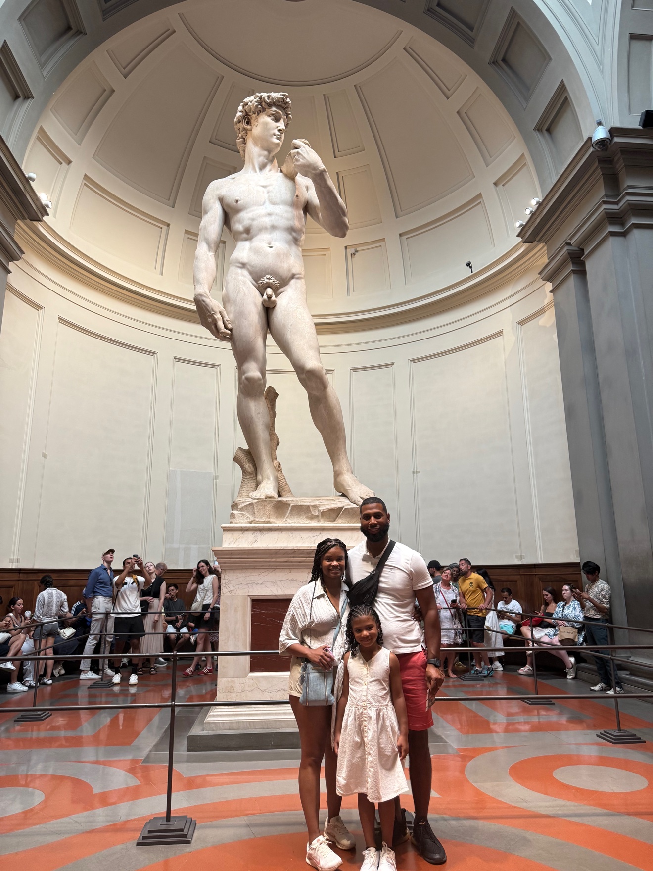 Dominique with his wife and daughter in front of Michelangelo's David in Florence